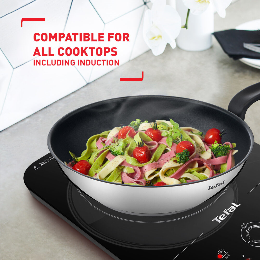 Titanium non-stick Tefal wok with vegetables tossing inside