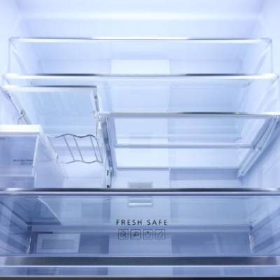 Refrigerator interior with transparent shelves and drawers labeled “Fresh Safe.”