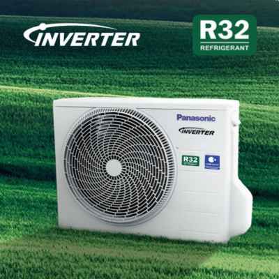 Panasonic inverter outdoor air conditioner unit with R32 refrigerant label on a green field.
